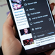 A photo of a person holding up an Android phone with the follow feature available on screen
